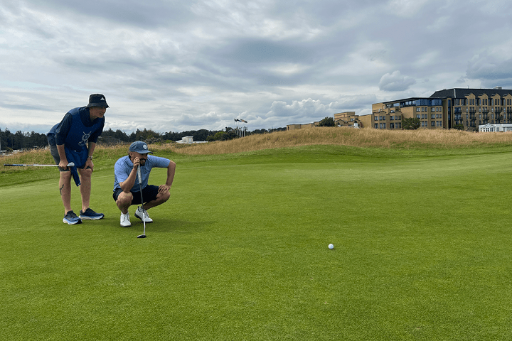 PGA professional golfer plays the iconic Old Course with The Experience Golf and lines up a putt with a caddie