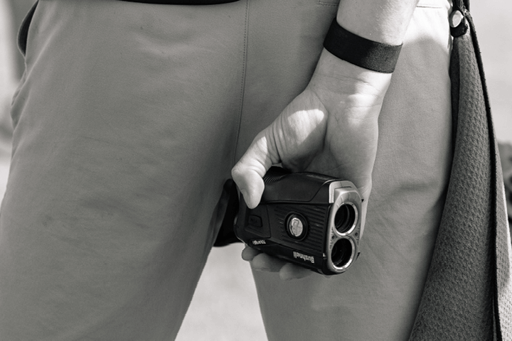 The Experience Golf guest holding a range finder GPS