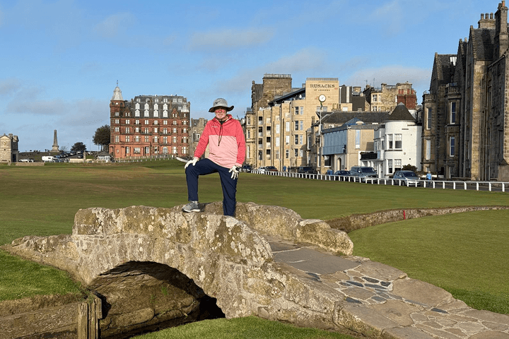 Guest posing for a photo on the Swilcan bridge in St Andrews Scotland