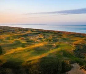 Royal Cinque Ports Golf Course overlooking the ocean at sunset.