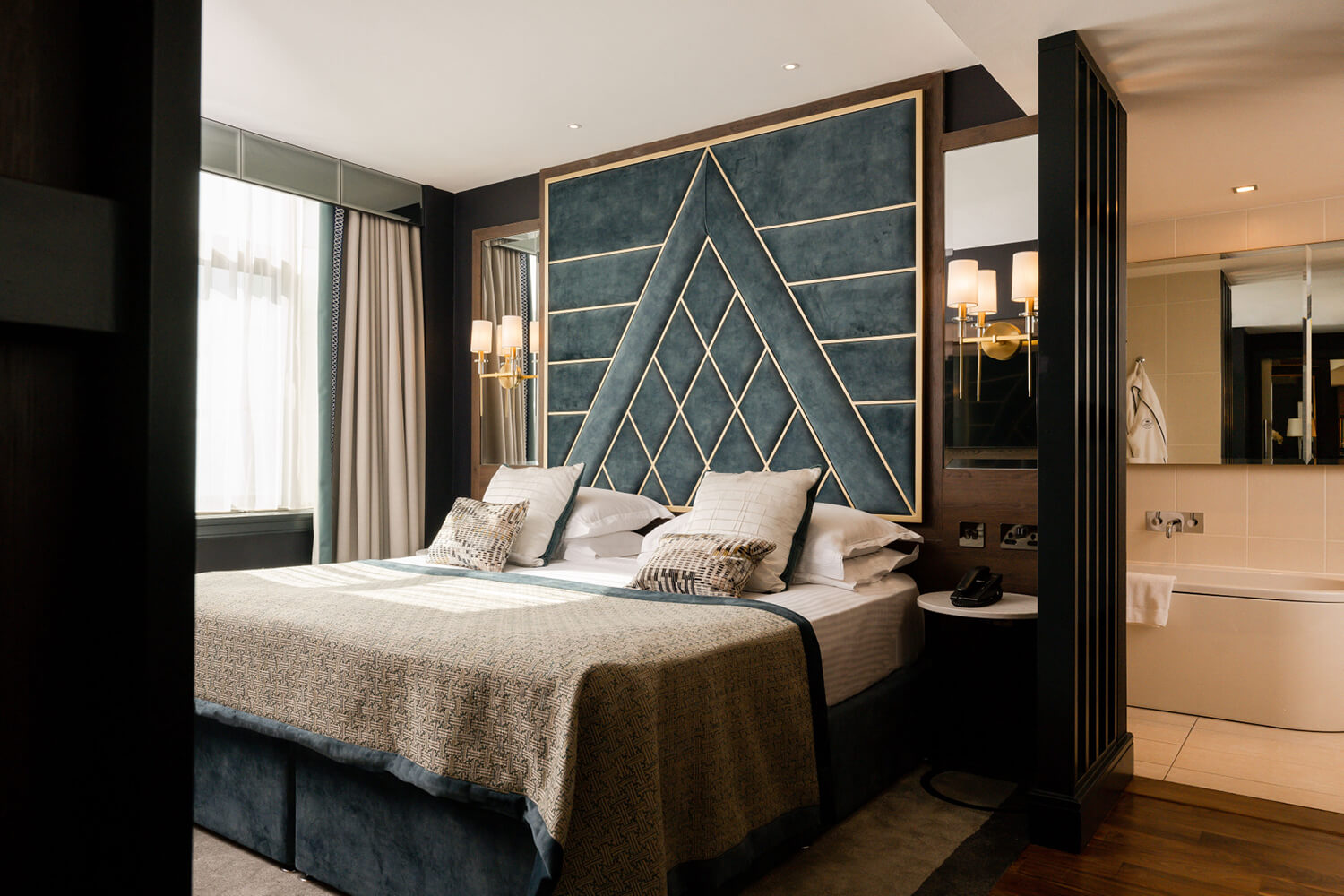 King size bedroom with bathroom in the background in the Europa Hotel.