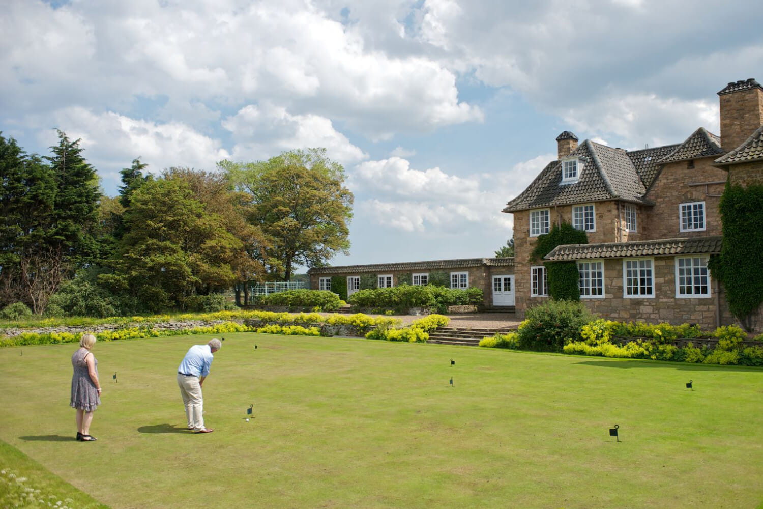 Outside the Greywalls Hotel with guests playing garden games on the lawn in Edinburgh Scotland