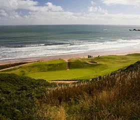 View of the green against the beach at Cruden Bay golf course in Scotland