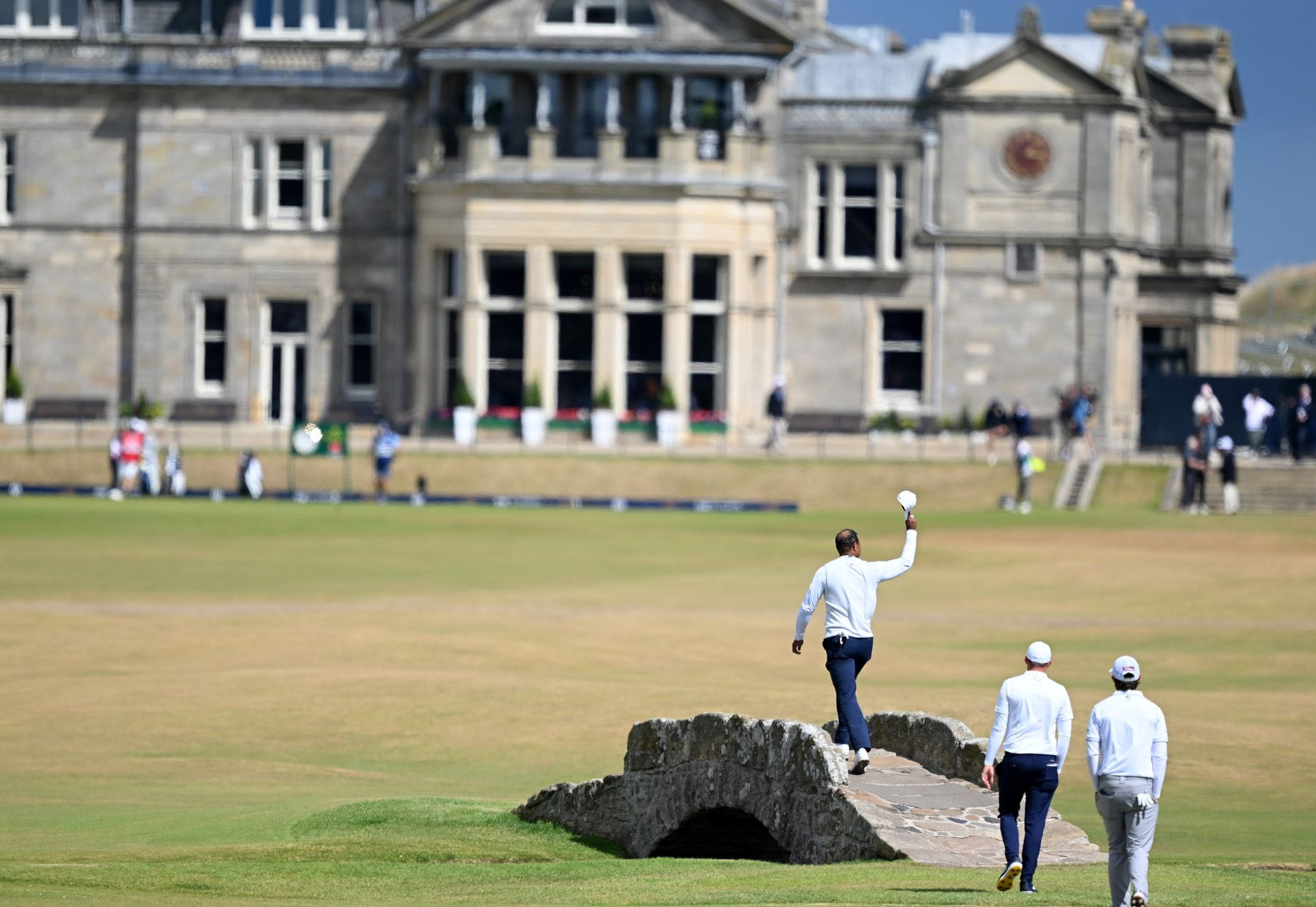 Tiger Woods acknowledges the crowd as he crosses the Swilcan Bridge during The 150th Open at St Andrews Old Course