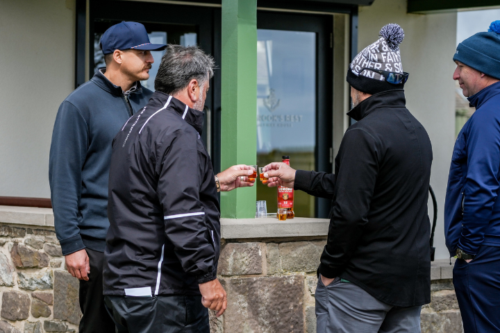 Fathers and son enjoying some whisky at Carnoustie Championship Course, Scotland.